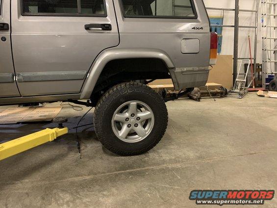 Silver 2000 Jeep Cherokee side view, lifted, with rear axle removed
