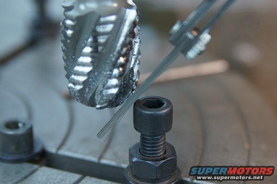 Milling cutter bit being measured with calipers against a metal rod