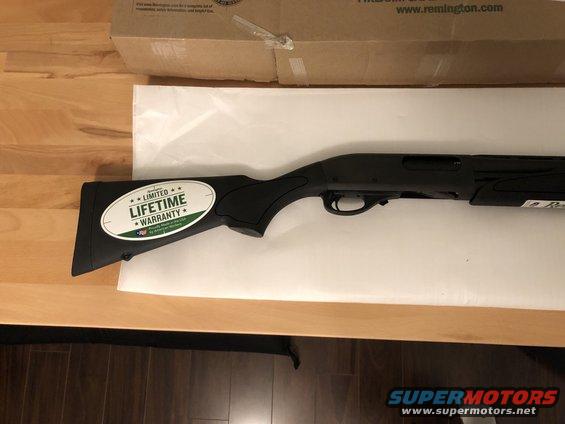 Black shotgun with "Limited Lifetime Warranty" sticker on the stock