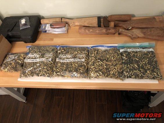 Bags of ammunition and wooden gun stocks on a table