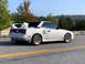 1989 Toyota MR2 - White 1989 Toyota MR2 with a prominent rear spoiler and aftermarket wheels.