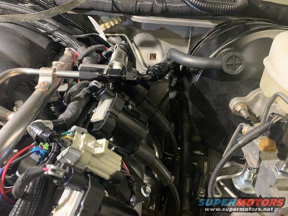 Engine bay with fuel lines, wiring harnesses, and brake booster