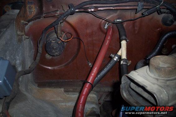 Close-up of heater hoses and blower motor assembly in a vehicle