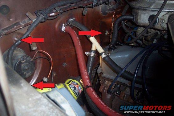 Engine bay with red and black hoses, wires, and a yellow fluid reservoir