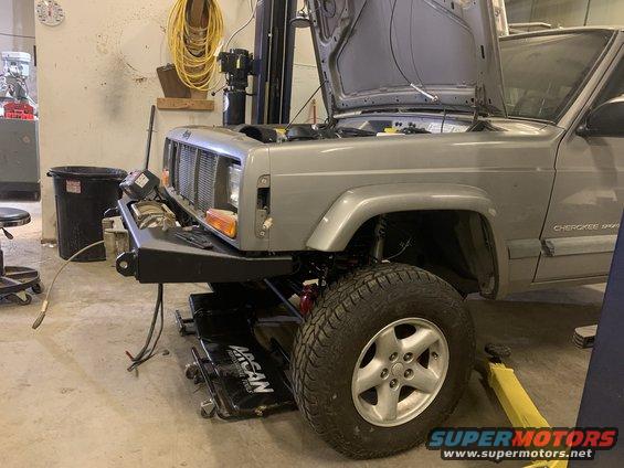 Silver 2000 Jeep Cherokee with hood open, front bumper replaced