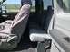 2011 Ford F-250 - The interior of a truck, gray fabric seats and seat covers, is visible from the side.
