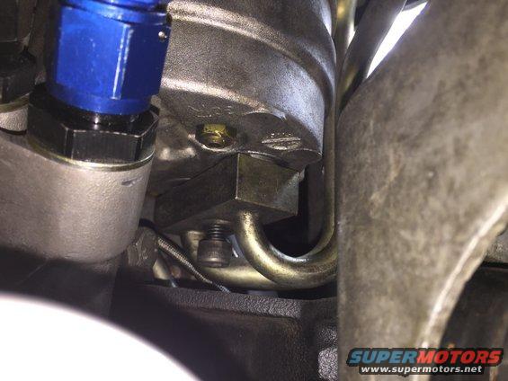 Close-up of engine component with blue fitting and metal tubing