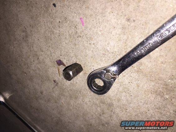 Lug nut and socket wrench on concrete surface
