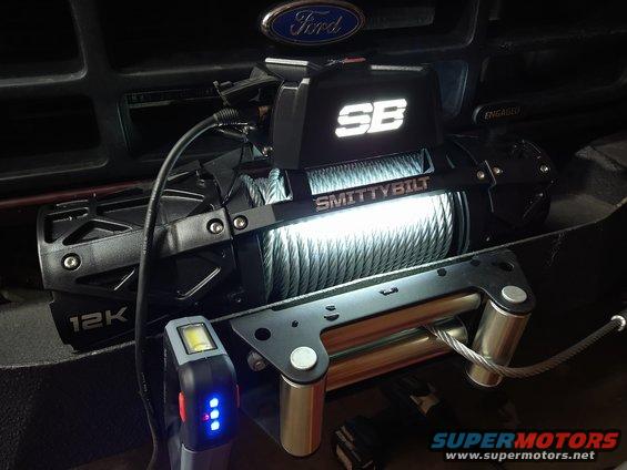 Smittybilt 12K winch with Ford emblem visible above. Small work light attached