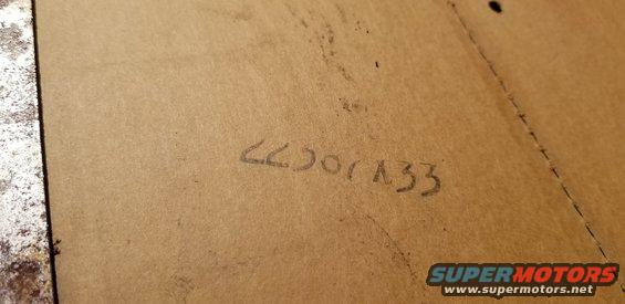 Handwritten numbers "66001A33" on a brown surface, possibly cardboard