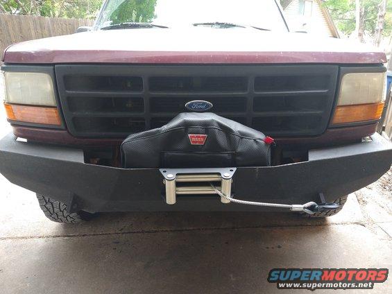 Maroon Ford Bronco front bumper with a black winch cover and a Warn logo