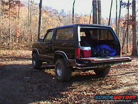 Black SUV with tailgate down, loaded with cooler and bags