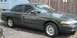 1997 Ford Crown Victoria - A dark green 1997 Ford Crown Victoria sedan is parked outdoors, showing its side profile and front quarter.