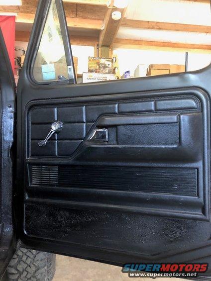 Black interior door panel with chrome window crank and door handle