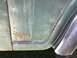1979 Jeep CJ5 - Rust is visible on the lower edge of a green vehicle's body panel, next to a chrome trim piece.