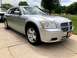 2006 Dodge Magnum - A silver Dodge Magnum station wagon is parked on a concrete driveway, with another vehicle partially visible to its left.