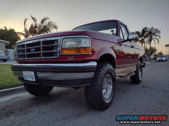 1994 Ford Bronco, red, lifted, parked on street