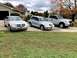 2004 Chrysler PT Cruiser - Three silver vehicles, including a 2004 Chrysler PT Cruiser, are parked in a driveway.
