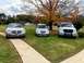 2004 Chrysler PT Cruiser - Three vehicles are parked on a lawn in front of a house on a cloudy day with autumn leaves on a tree.
