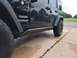 2015 Jeep Wrangler - Side view of a black 2015 Jeep Wrangler Unlimited showing its body style and aftermarket accessories.
