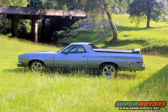 Light blue 1972 Ford Ranchero pickup truck parked in tall grass, side view