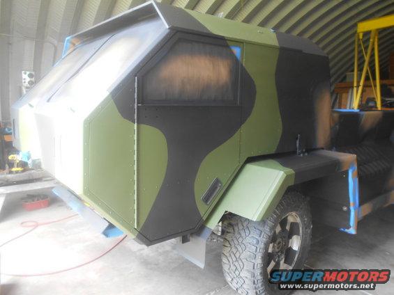 Camouflaged vehicle cabin with angular design and tinted windows