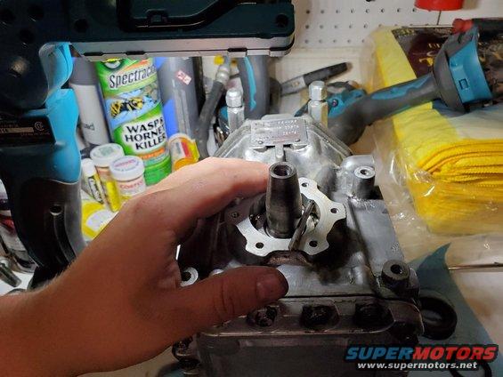 Air compressor part with visible text plate and a hand holding it