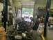 1979 Jeep CJ5 - Mechanics are working on a vehicle's engine and frame inside a garage.