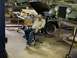 1979 Jeep CJ5 - A man sits in a chair in a workshop next to a green 1979 Jeep CJ5, which has its hood raised.