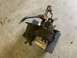 1979 Jeep CJ5 - Transfer case with linkage, resting on a blue mat over a yellow jack on a concrete floor.