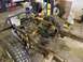 1979 Jeep CJ5 - The frame and suspension of a Jeep CJ5 are shown in a workshop, with tires and drivetrain parts visible.