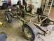 1979 Jeep CJ5 - The chassis of a vehicle is shown with its suspension and wheels, undergoing work in a garage.