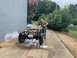 1979 Jeep CJ5 - A man pressure washes the frame of a Jeep CJ, which is missing its body panels and engine.
