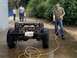 1979 Jeep CJ5 - A man pressure washes the chassis of a 1979 Jeep CJ5, revealing its Texas license plate.