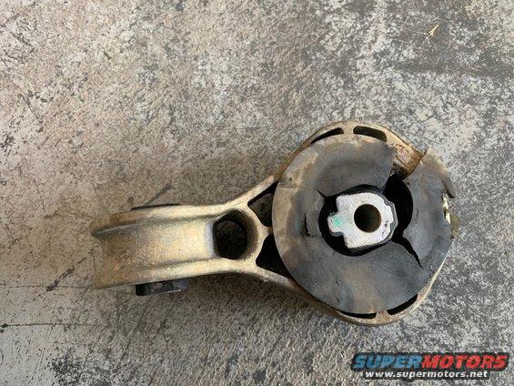 Damaged engine mount with cracked rubber. Shows a metal bracket attached to a rubber bushing