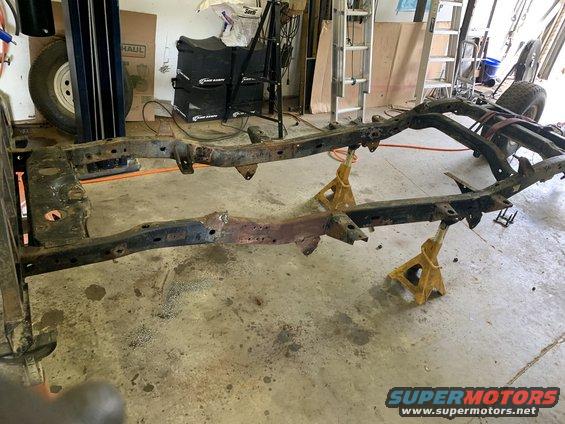 Vehicle frame on jack stands, showing rust and wear