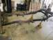 1979 Jeep CJ5 - The frame of a vehicle, likely undergoing restoration or repair, is supported by yellow jack stands in a garage setting.