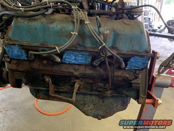 Blue engine block with spark plug wires and blue tape on spark plug holes
