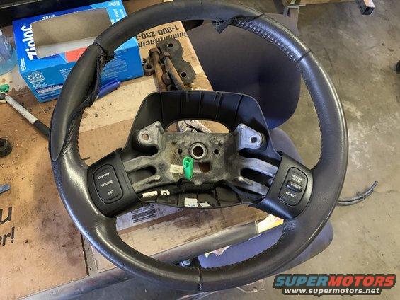 Steering wheel with cruise control buttons, showing wear and tear