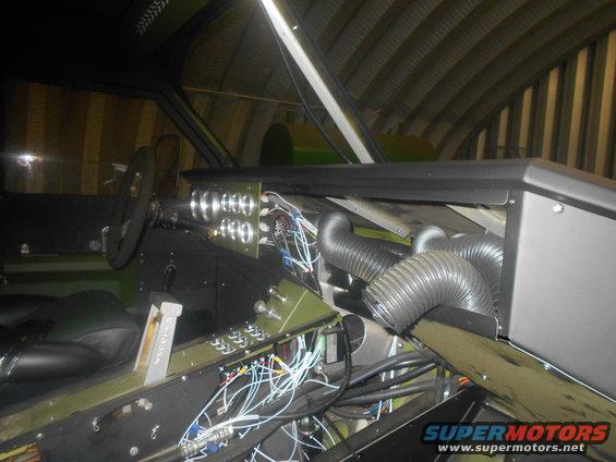 Vehicle interior with exposed wiring, gauges, and flexible ducting