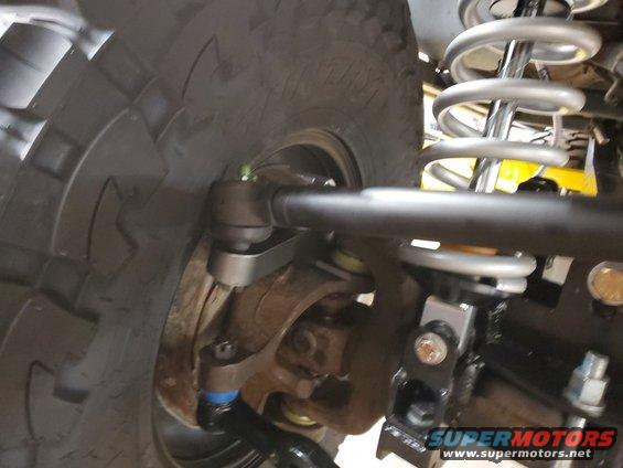 close-up of vehicle's front wheel, tie rod, and coilover shock assembly