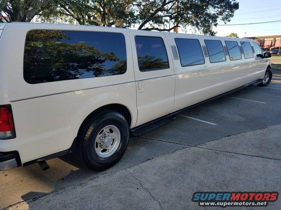 White stretch limousine, side view. Looks like a Ford Excursion base