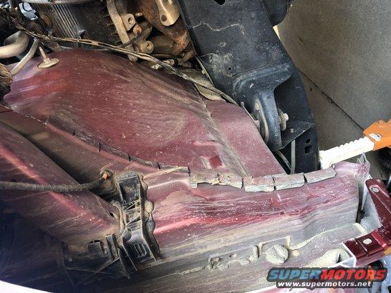 Undercarriage of red vehicle with visible suspension components and wiring