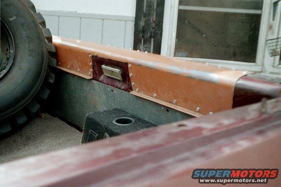 Interior view of a vehicle with a large tire and copper-colored trim