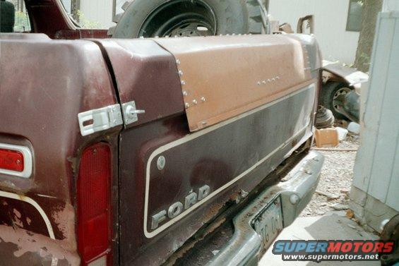 1979 Ford Bronco rear quarter panel with Ford badging and a camper shell. A spare tire is visible above the shell