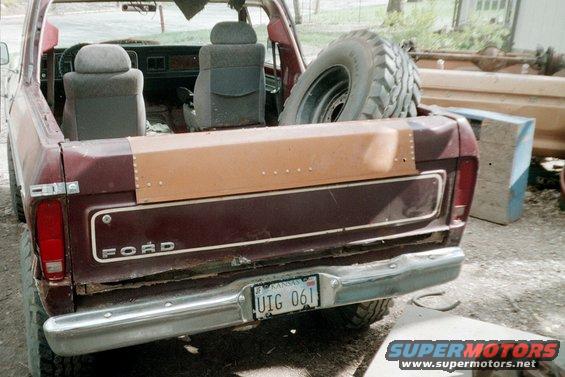 Rear view of a maroon Ford Bronco with a spare tire in the back. The license plate reads UIG 061
