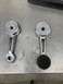 1968 Ford Mustang - Pair of chrome window cranks, one with a black rubber knob, displayed on a workbench.