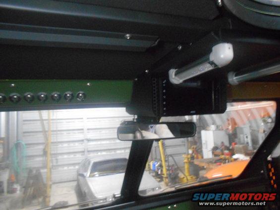 Interior of a vehicle with toggle switches and an electronic device mounted overhead.