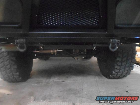 Front view of a vehicle's bumper, tow hooks, and large tires