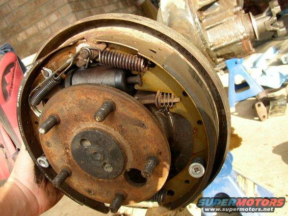 Rusty rear drum brake assembly with brake shoes and wheel cylinder